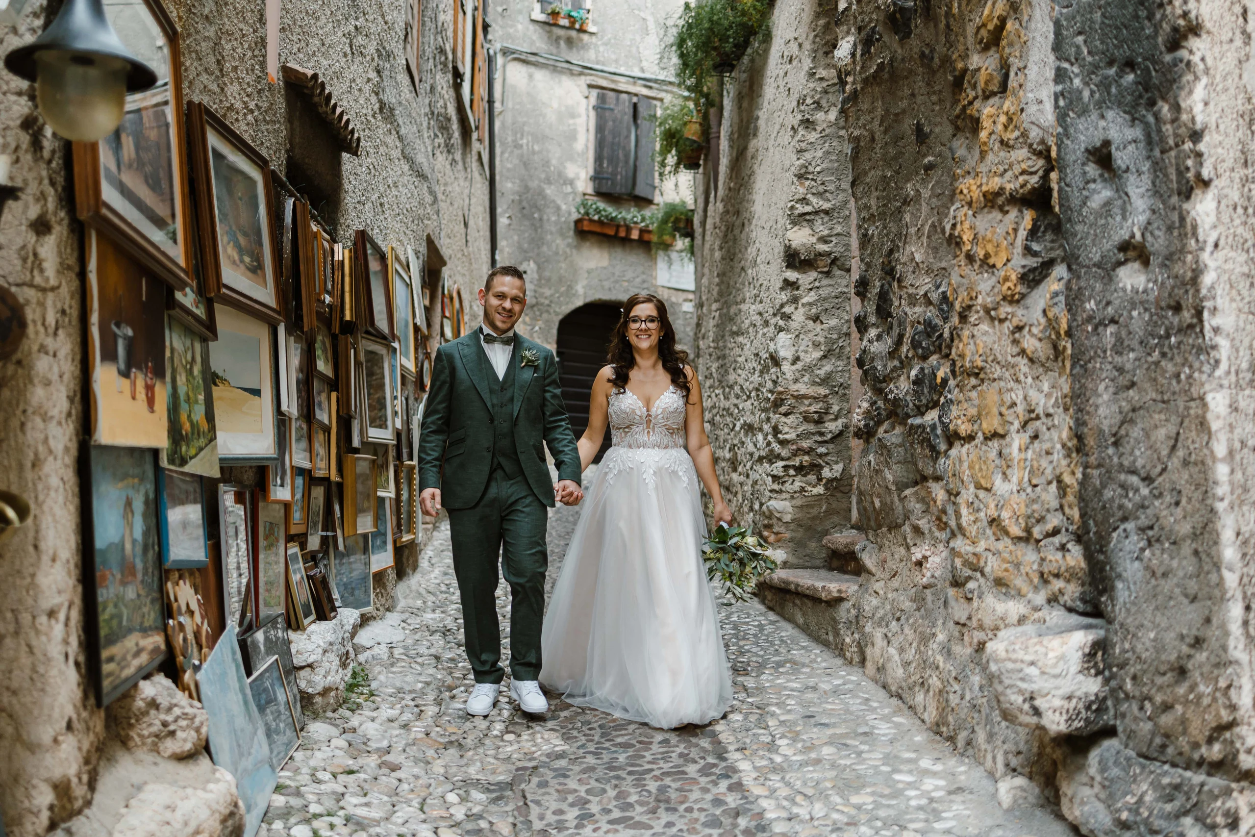 Brautpaar spaziert durch eine historische Altstadtgasse am Gardasee