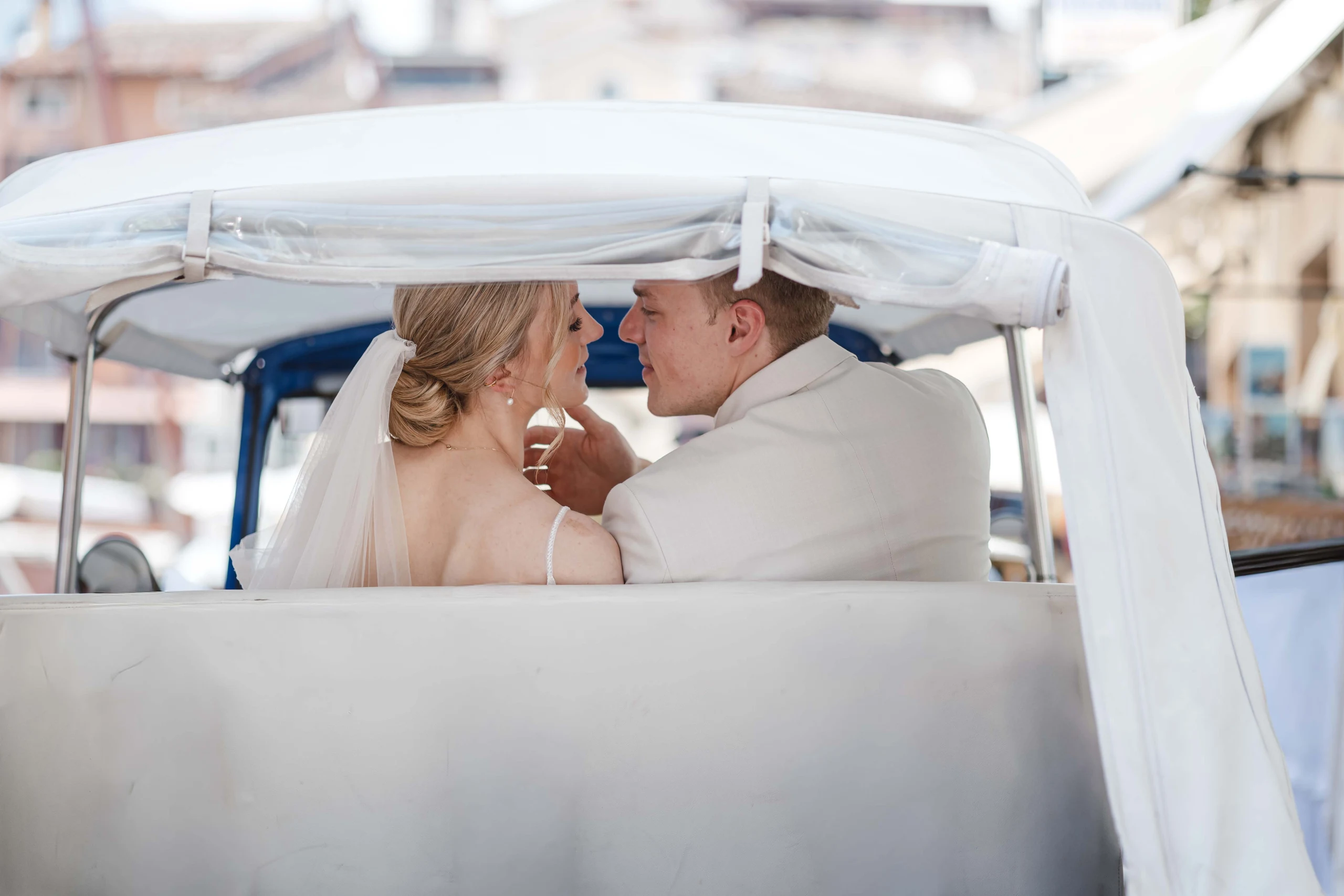Brautpaar in einem Hochzeitsfahrzeug während seines Hochzeitstags am Gardasee