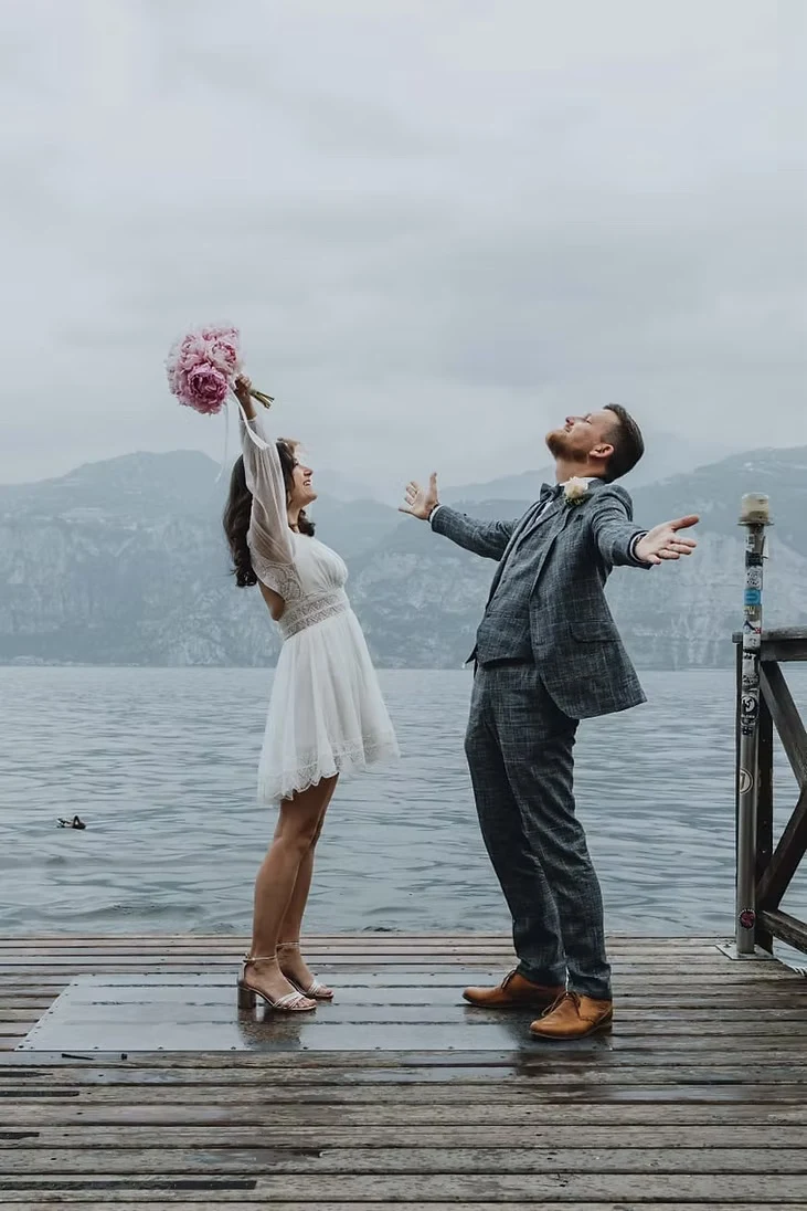 Brautpaar bei einem ausgelassenen Moment auf einem Holzsteg am Gardasee