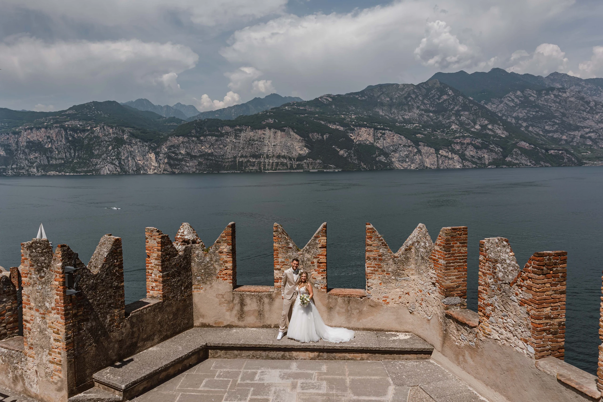 Braut auf einer historischen Burgterrasse mit Blick über den Gardasee